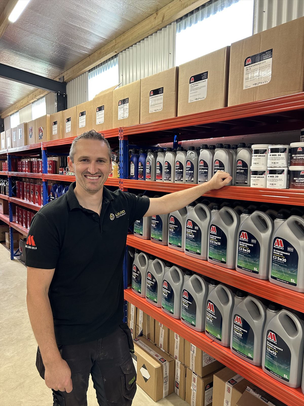 Shane Stafford of Liquid Technology beside the Millers Oils shelves